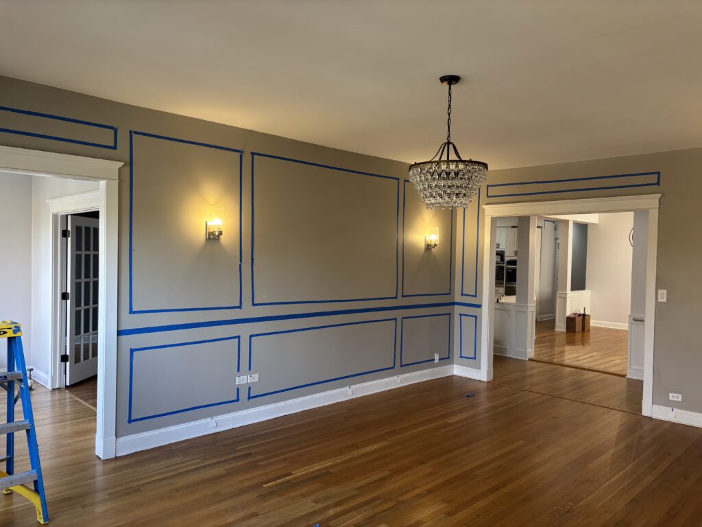 wainscoting installation chicago layout planning shows blue tape on the wall where future wall trim will be installed
